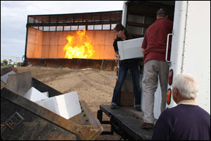 DEA personnel unload boxes of prescription drugs into a front-end loader prior to incineration in Kennedale, Texas.